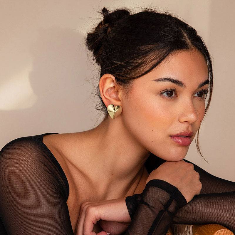 Golden-colored earrings with small raised hearts